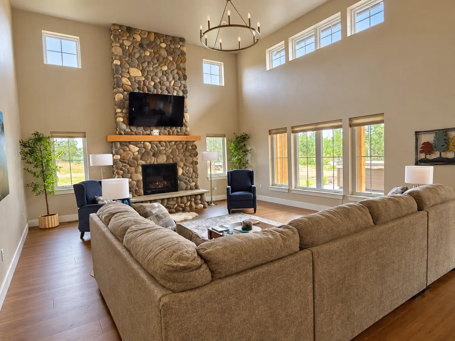 The great room with river-stone fireplace and tall windows